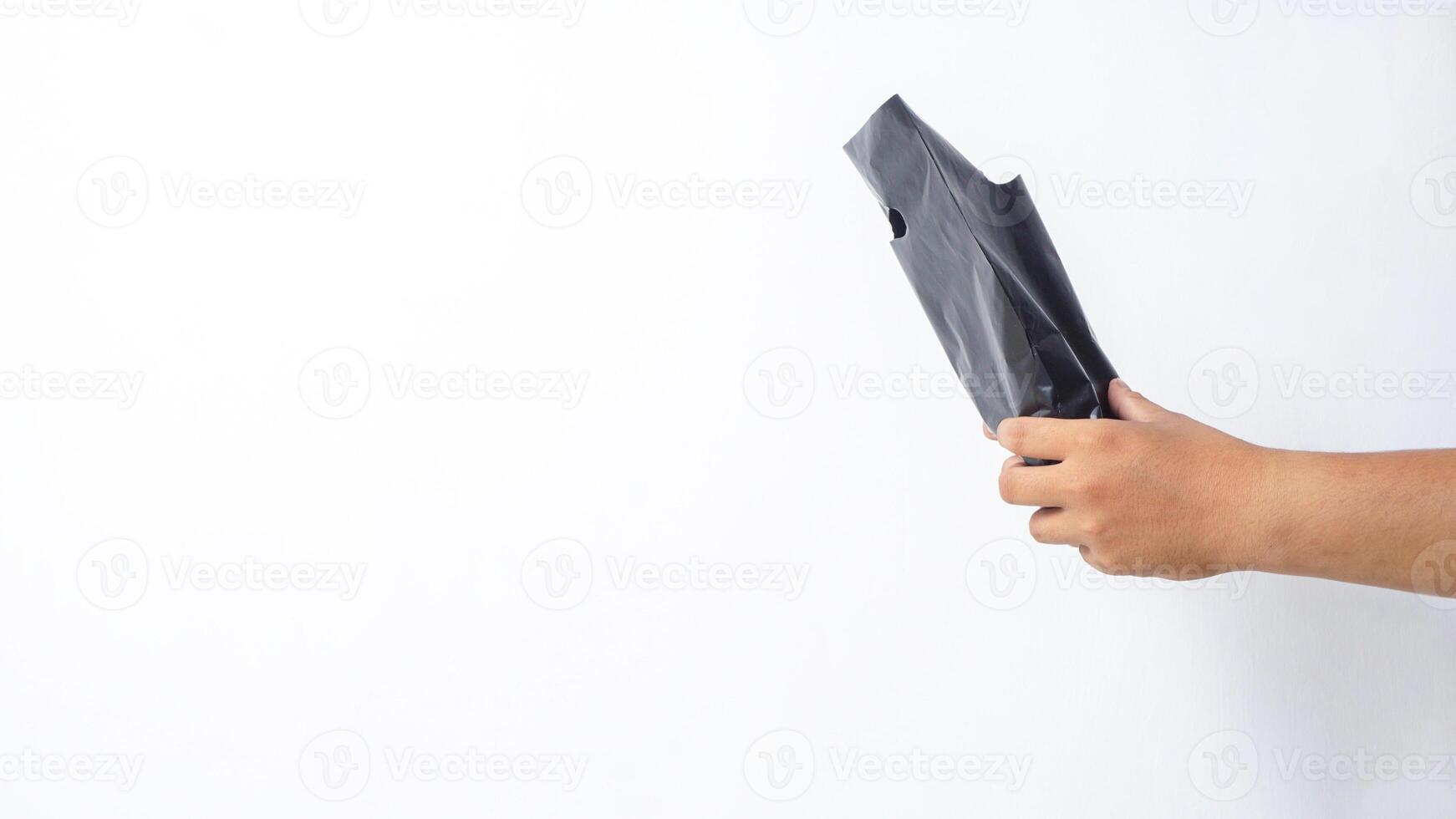 Hand Giving Black Plastic Bag on White Background photo