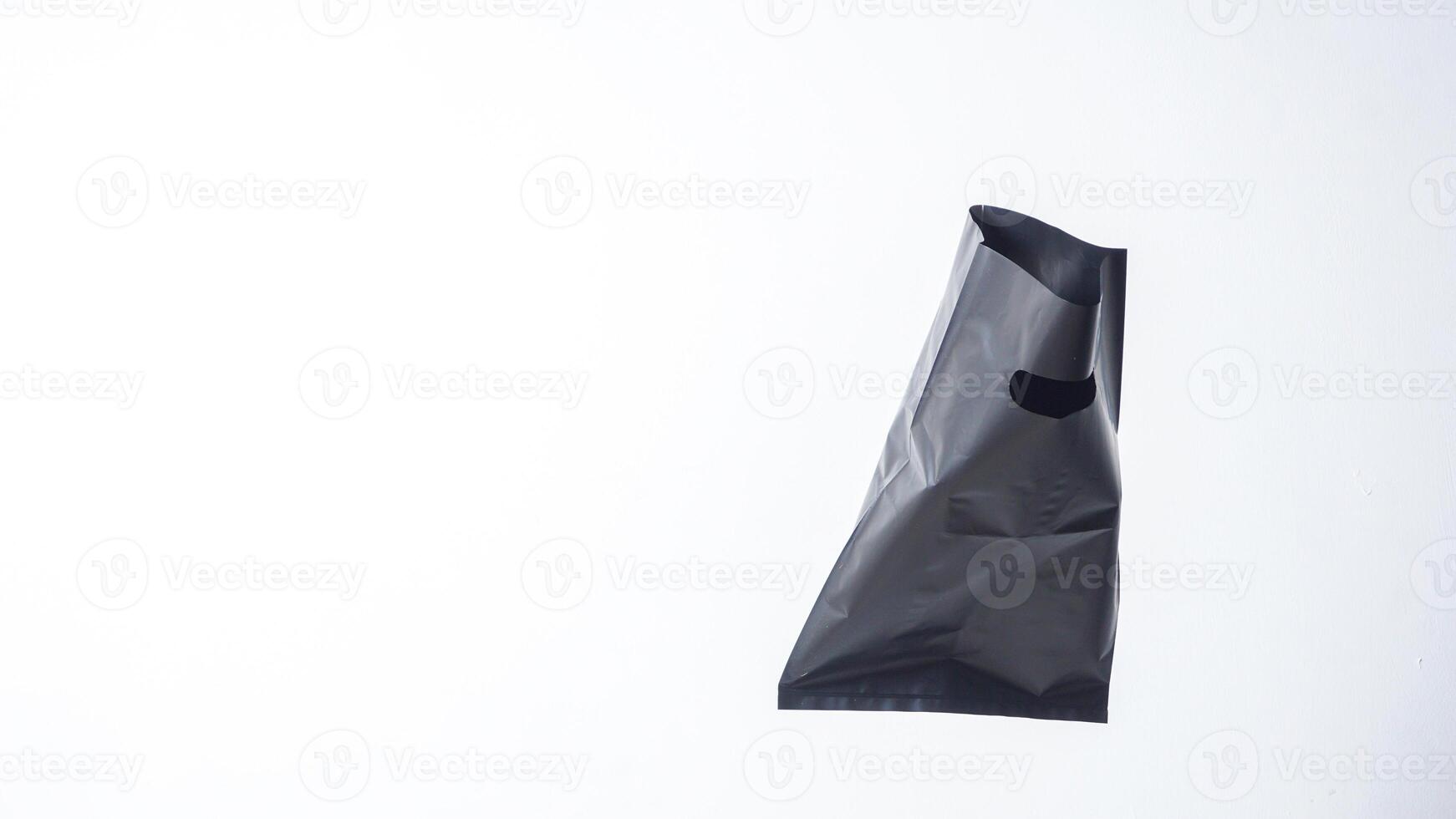 Open Black Plastic Bag with Copy Space on White Background photo