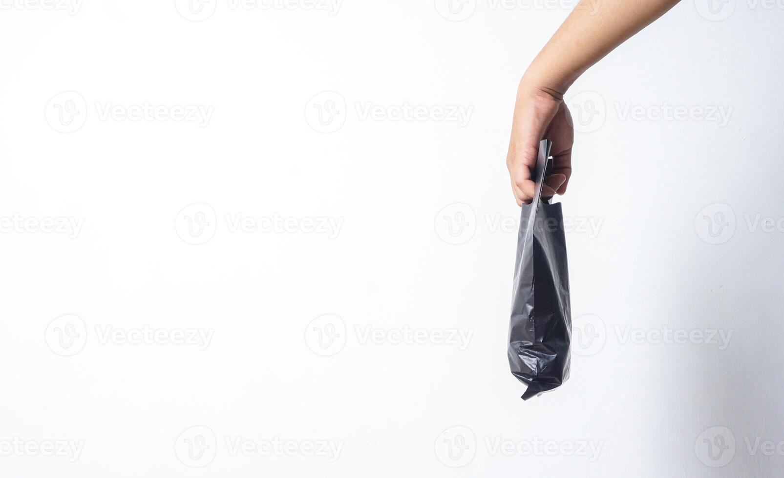 Side View of Hand Carrying Black Plastic Bag on White Background photo
