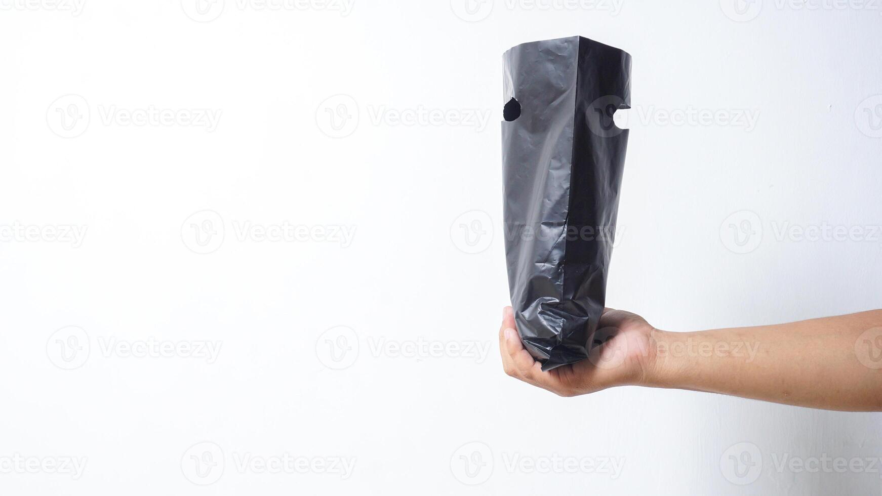 Man Hand Holding Open Black Plastic Bag on White Background photo