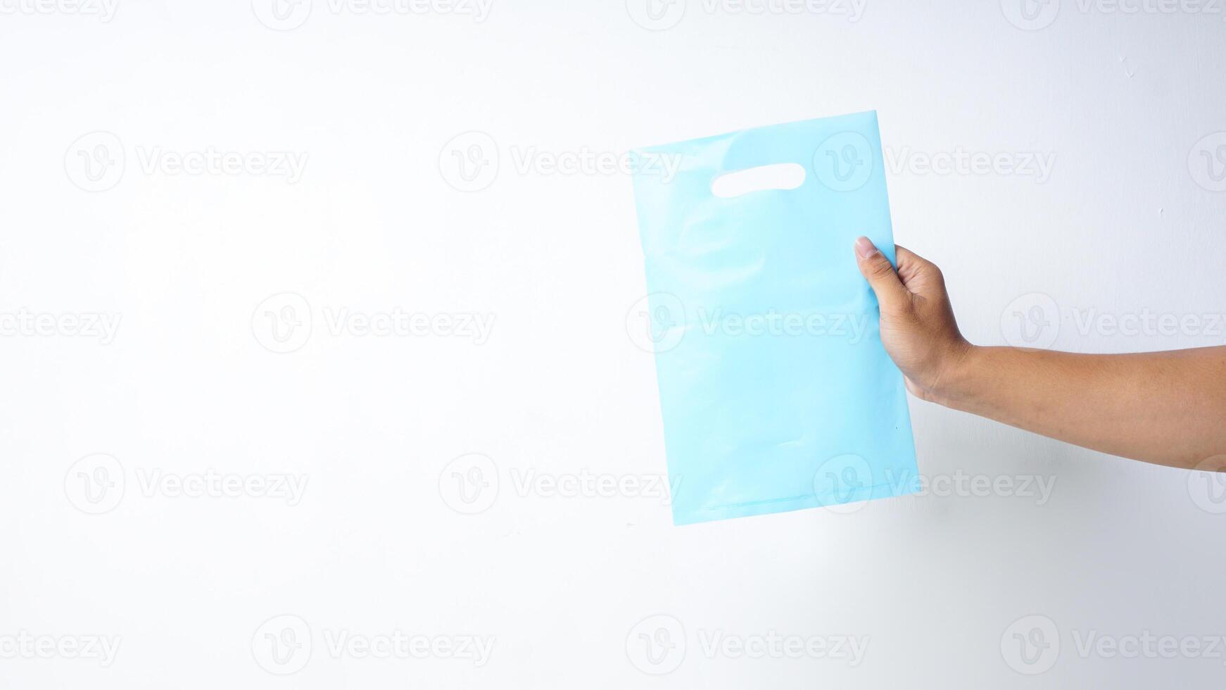 Hand Shows Light Blue Plastic Bag Mock Up on White Background photo