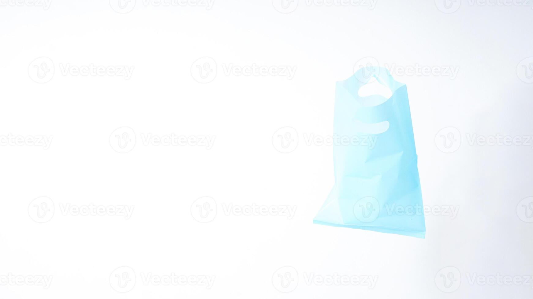Empty Open Light Blue Plastic Bag with Handle on White Background photo
