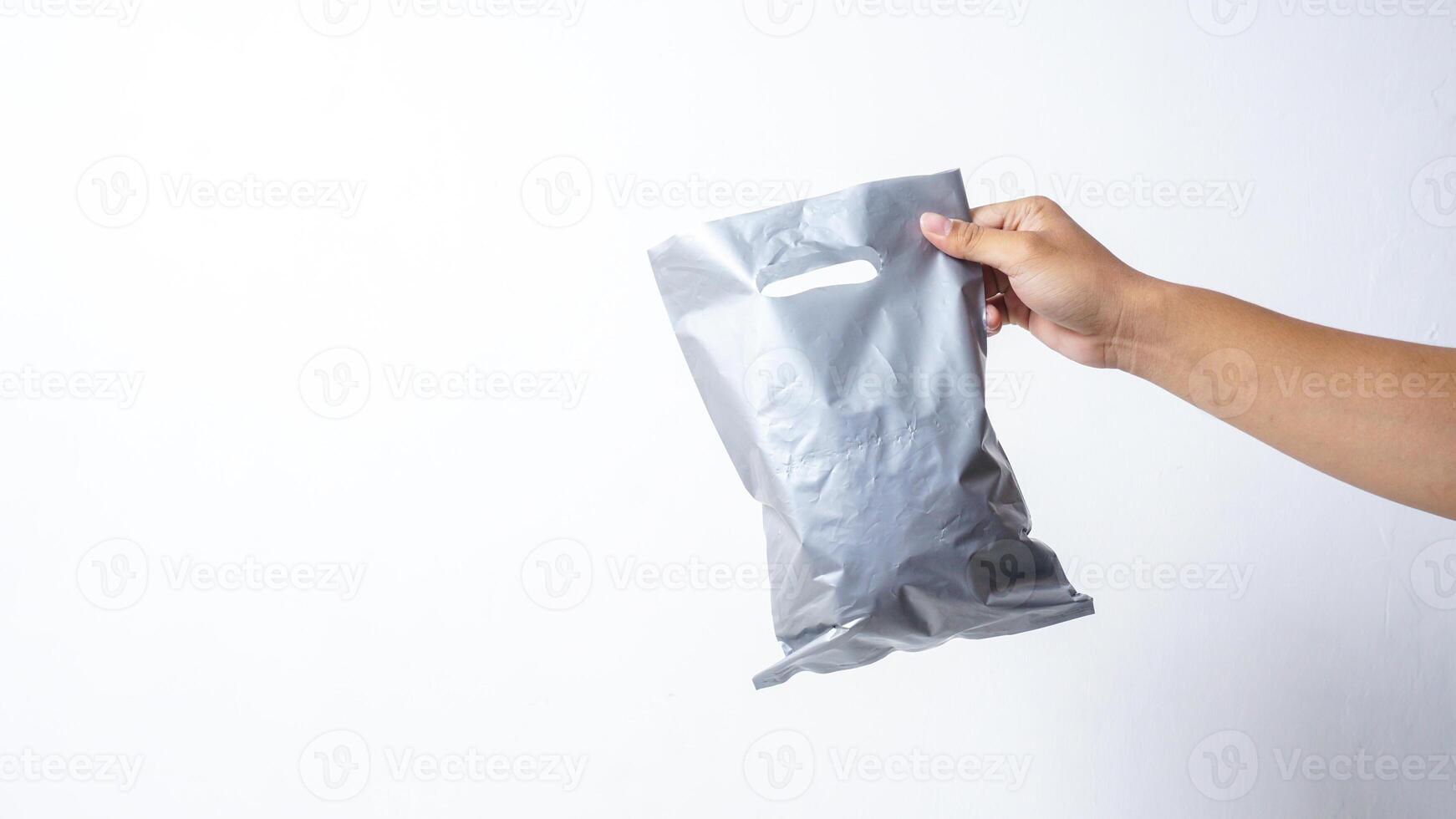 Hand Holding Filled Gray Plastic Bag on White Background photo