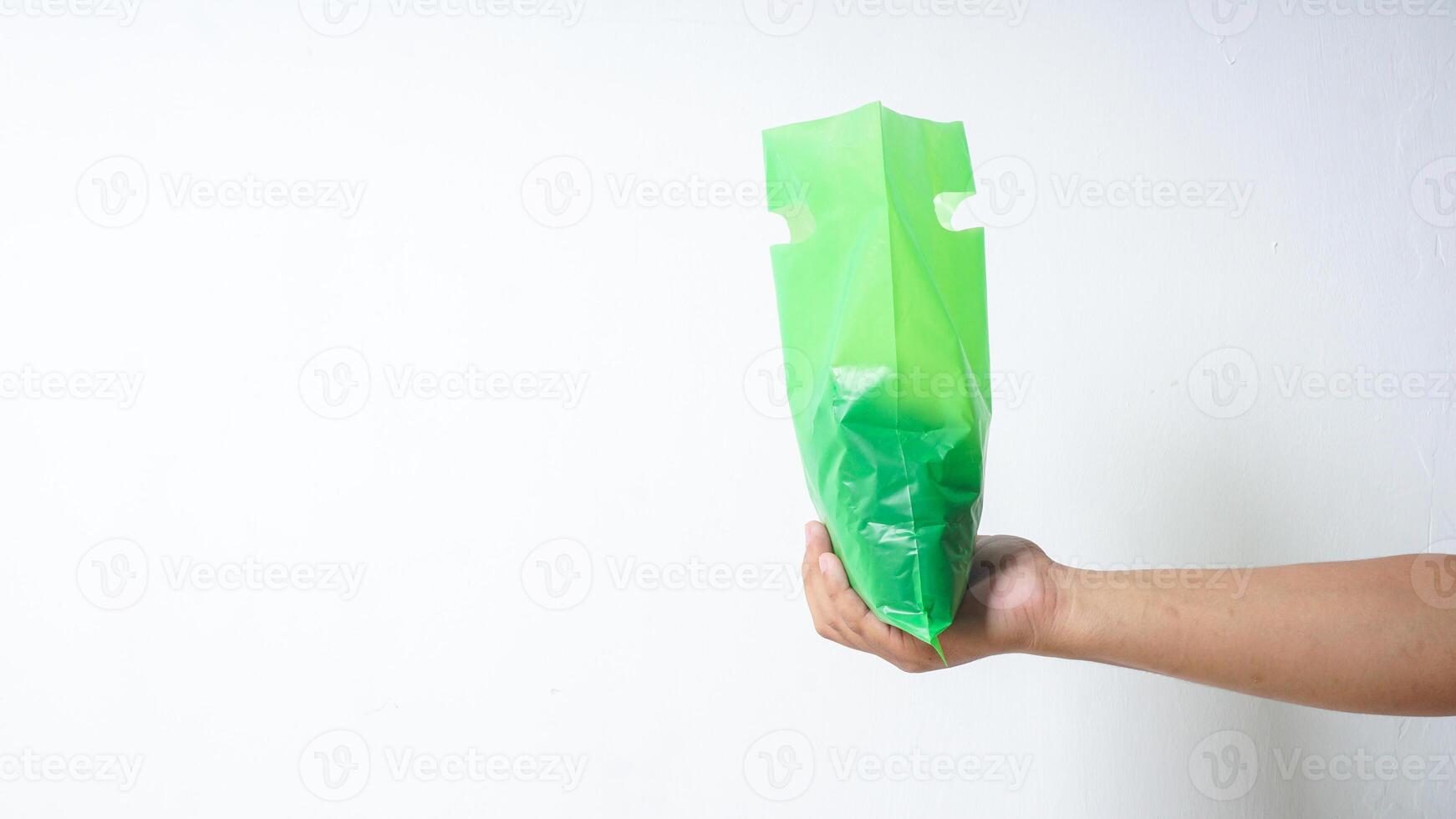 Hand with Green Plastic Bag on White Background photo