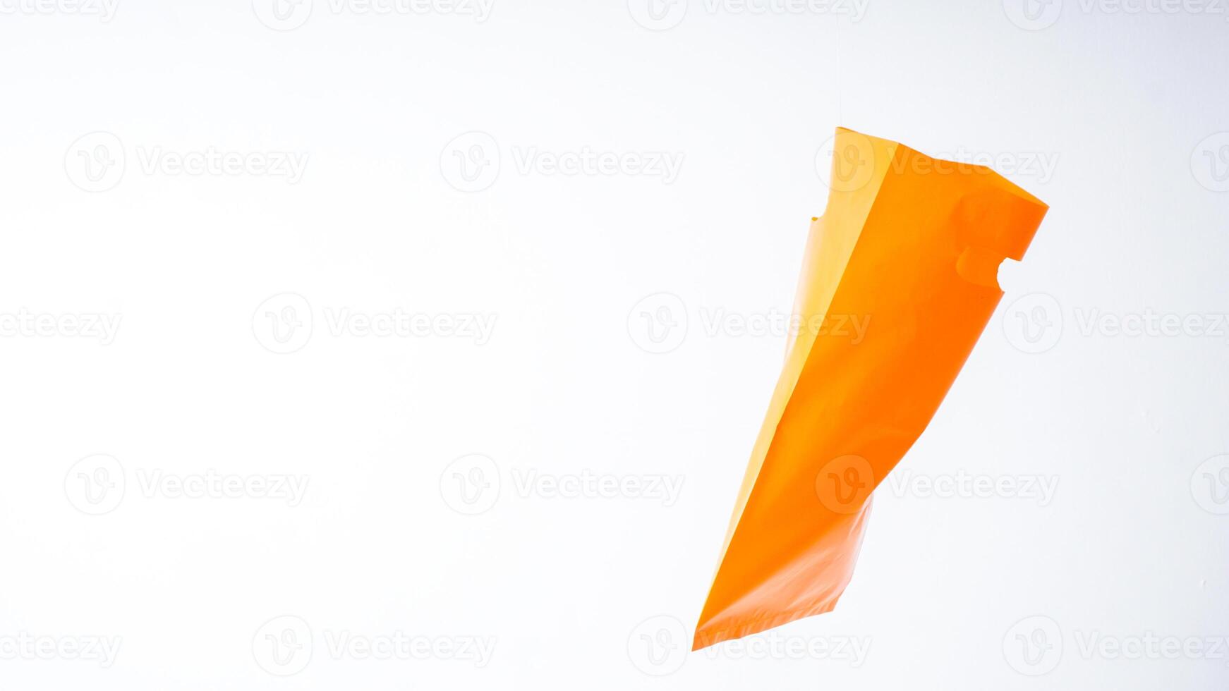 Side View of Orange Plastic Grocery Bag on White Background photo