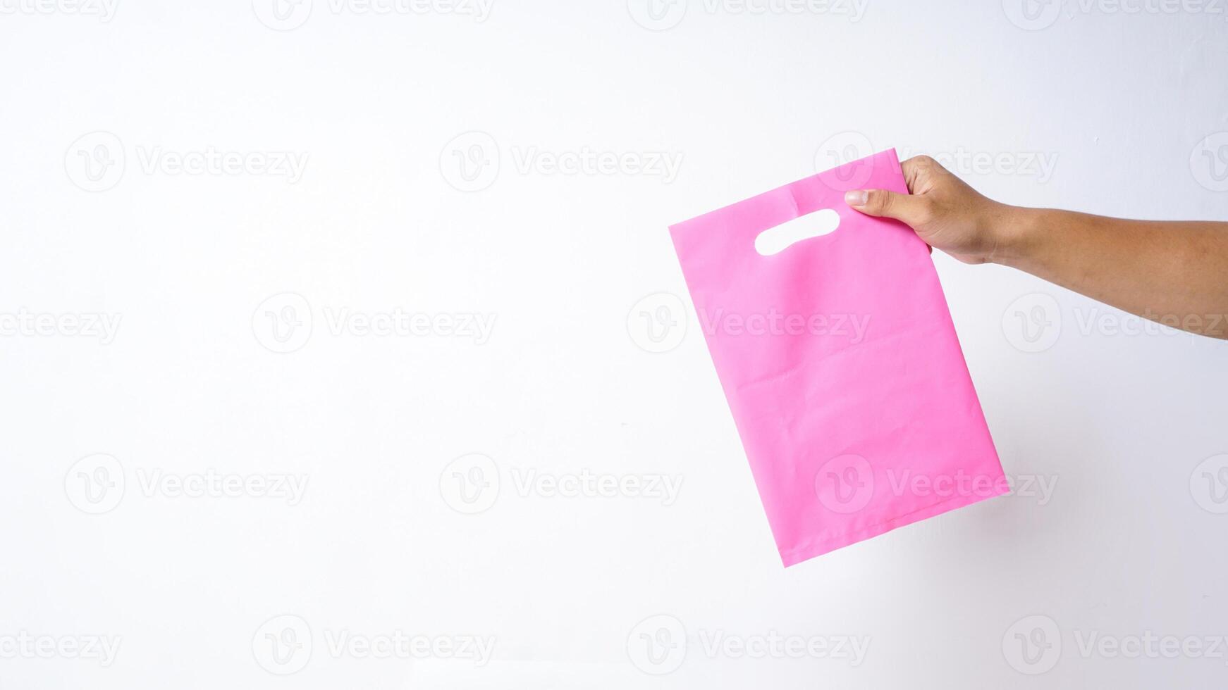 Hand Holding Pink Plastic Bag Mock Up on White Background photo