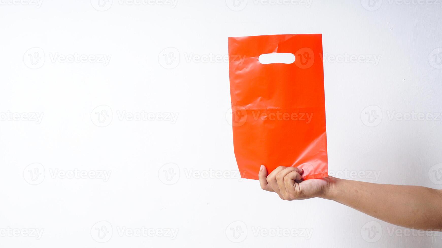 Hand Showing Red Plastic Bag on White Background photo