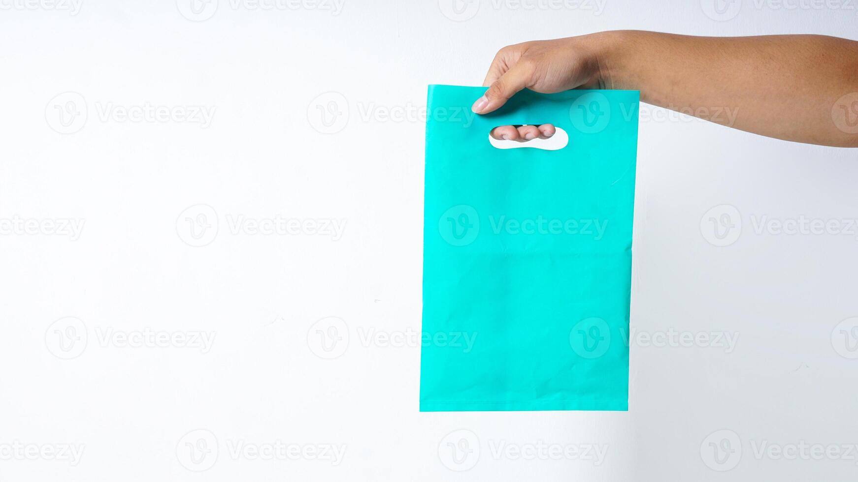 Hand Carrying Turquoise Plastic Bag Mock Up on White Background photo