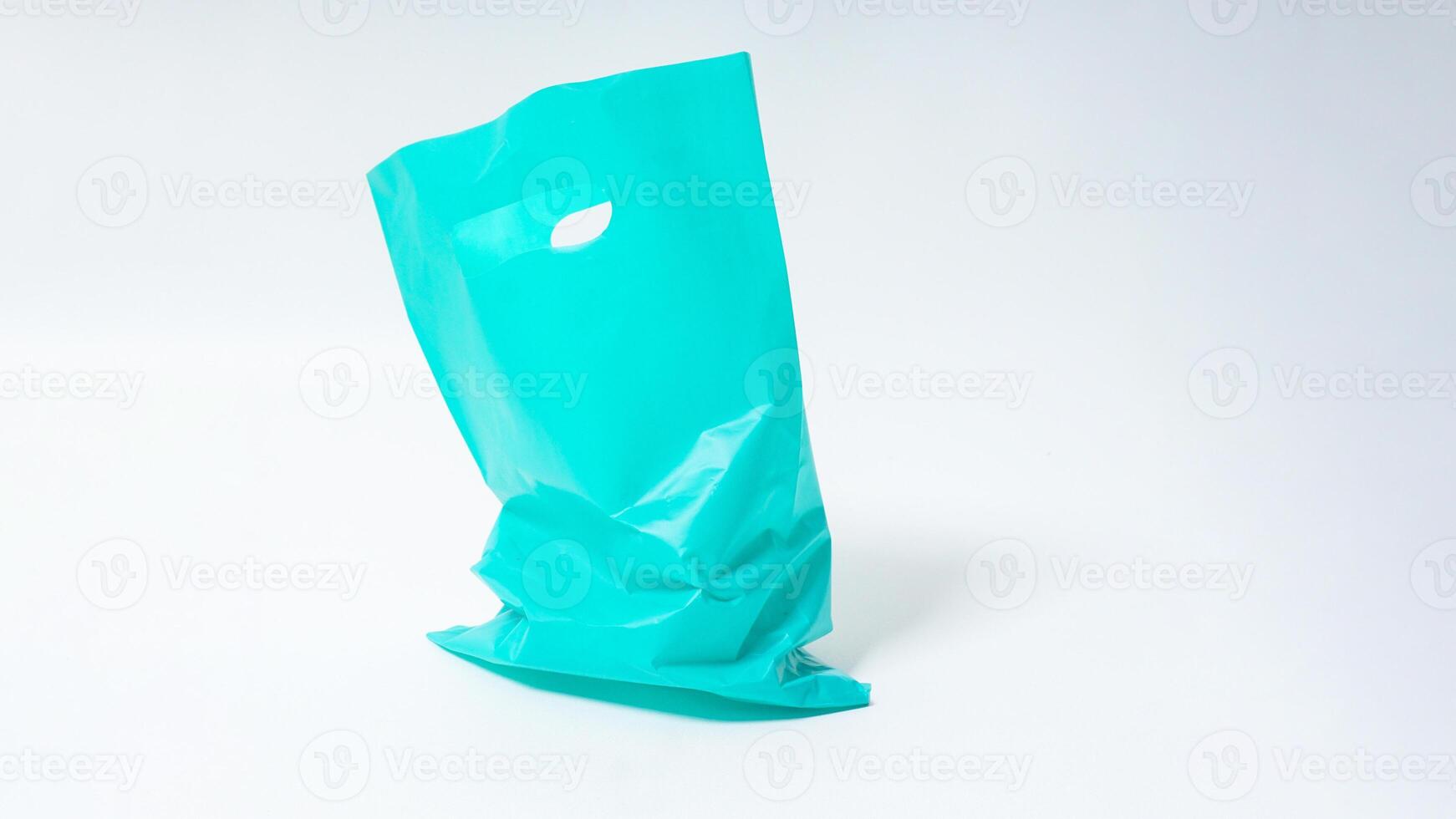 Empty Open Turquoise Plastic Bag on White Background photo