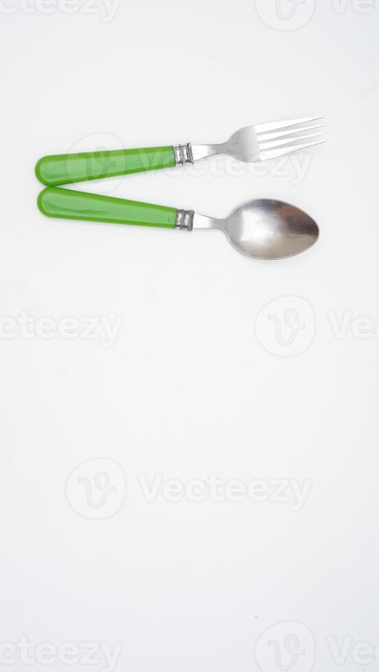 A pair of stylish stainless steel spoon and fork with green handle with copy space isolated on white background photo