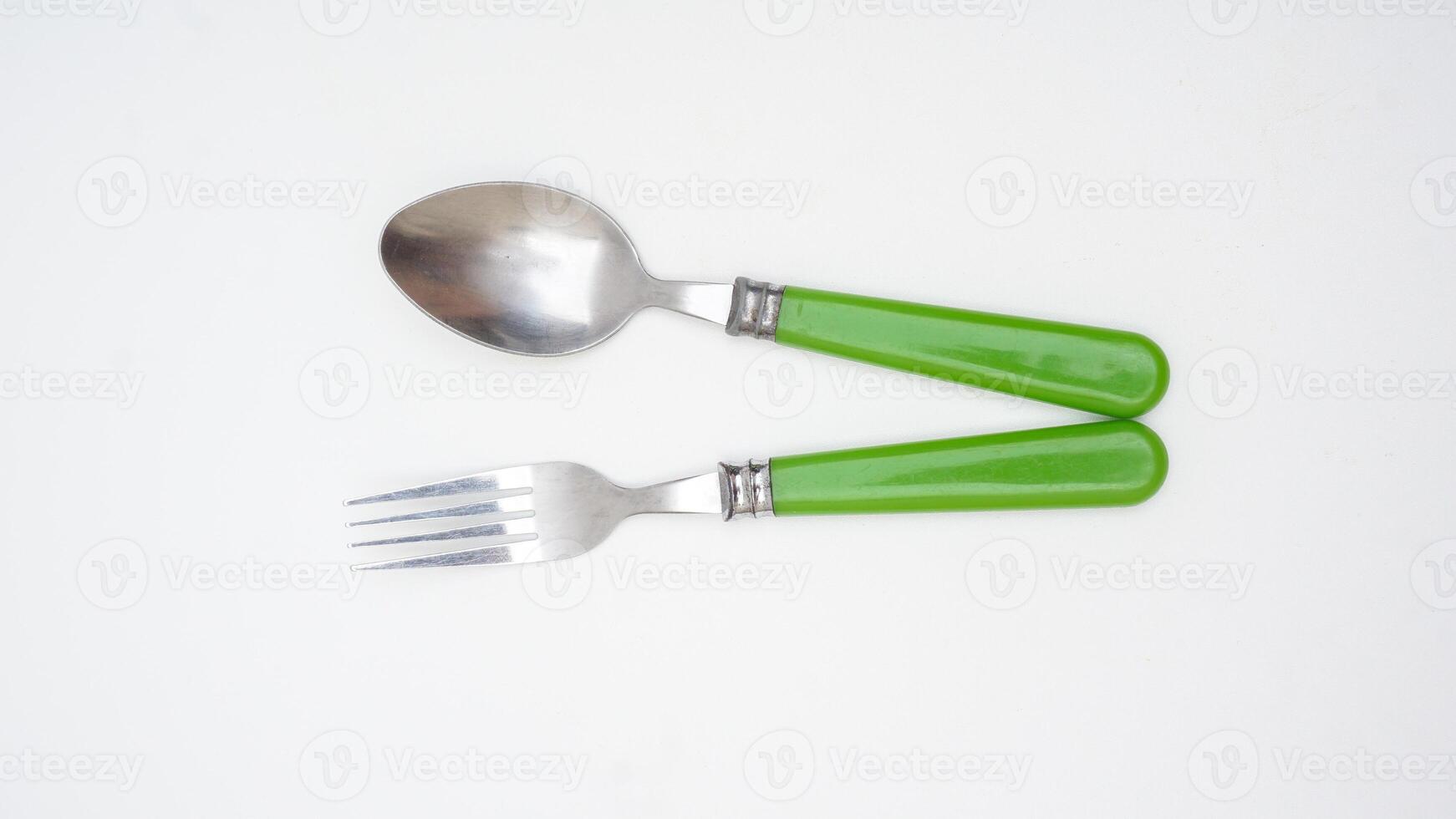 Stylish stainless steel spoon and fork with green handle isolated on white background photo