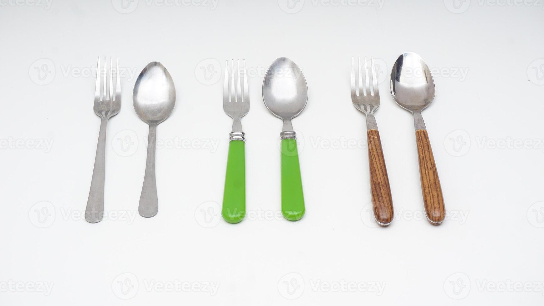 Three pairs of stainless steel spoon and fork isolated on white background photo