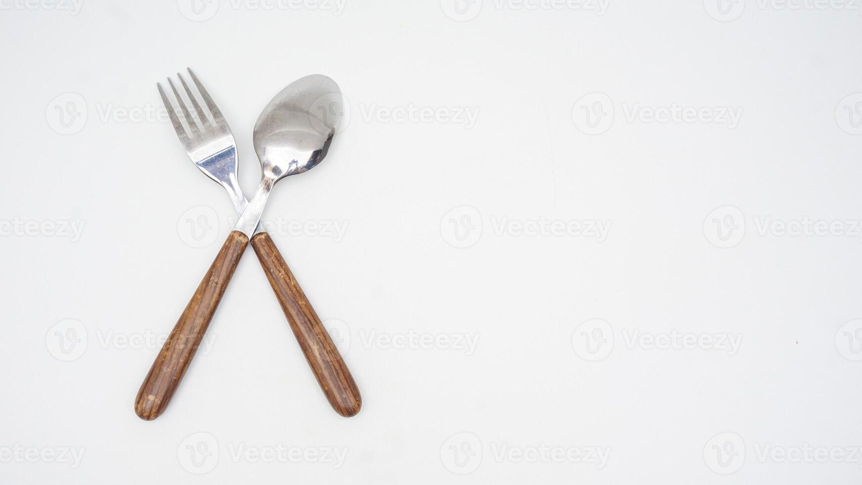 Rear view of modern stainless steel spoon and fork with wooden handle isolated on white background photo
