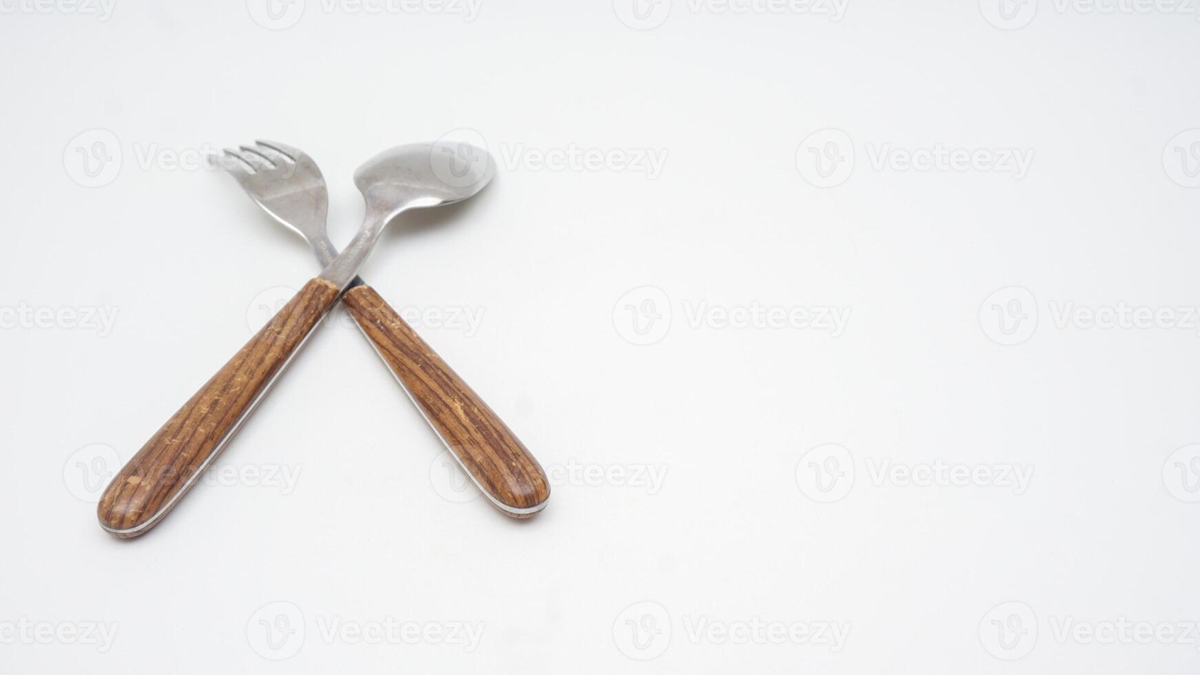 Rear view of a pair of stainless steel cutlery with wooden handle isolated on white background photo