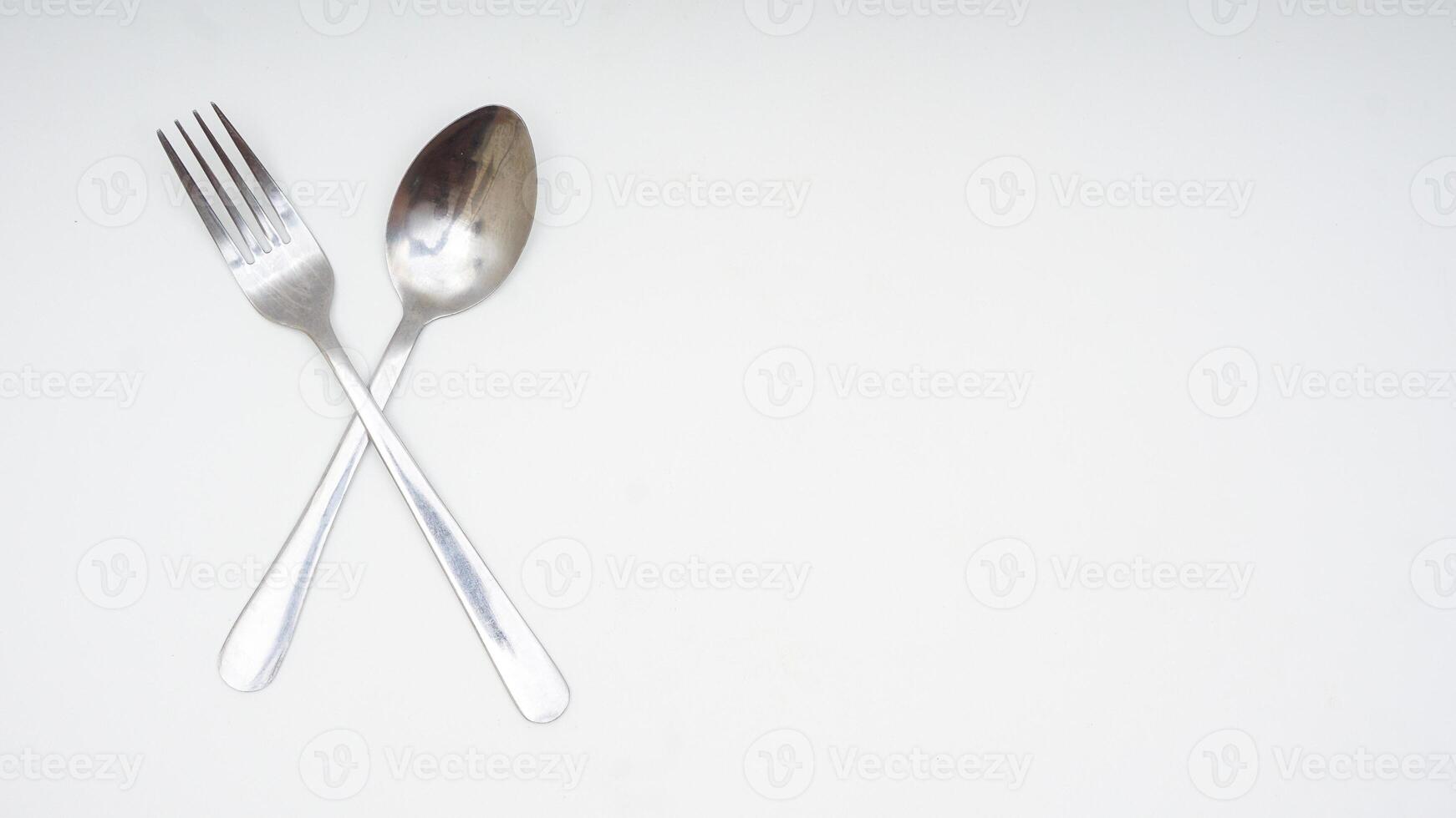 Stainless steel spoon and fork with copy space isolated on white background photo