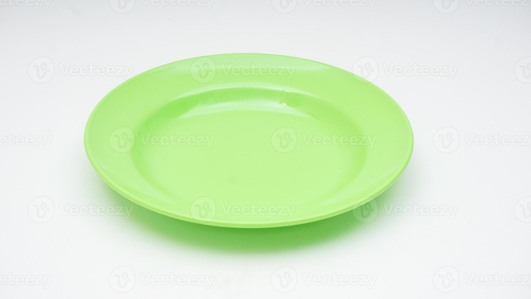 Round green melamine plate isolated on white background photo