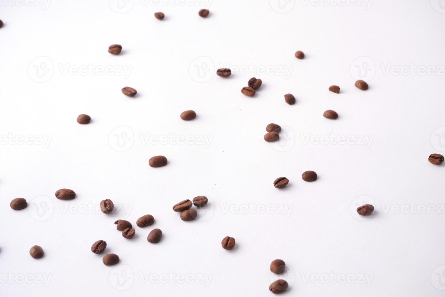 Scattered roasted coffee beans on white background photo