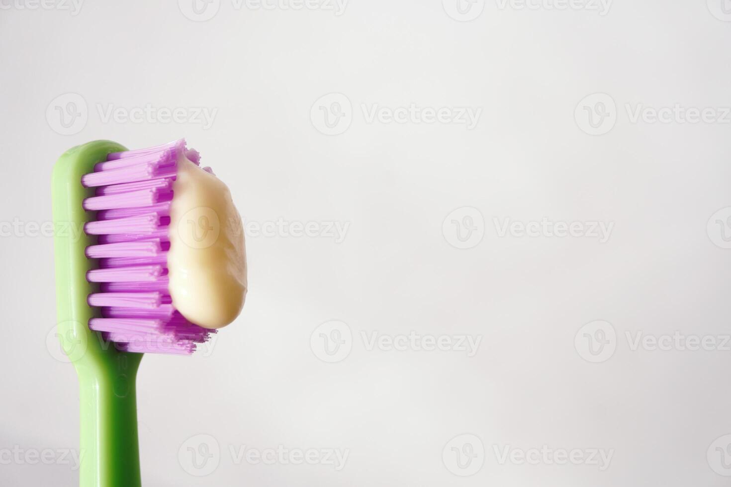 Green toothbrush with toothpaste on bristles photo