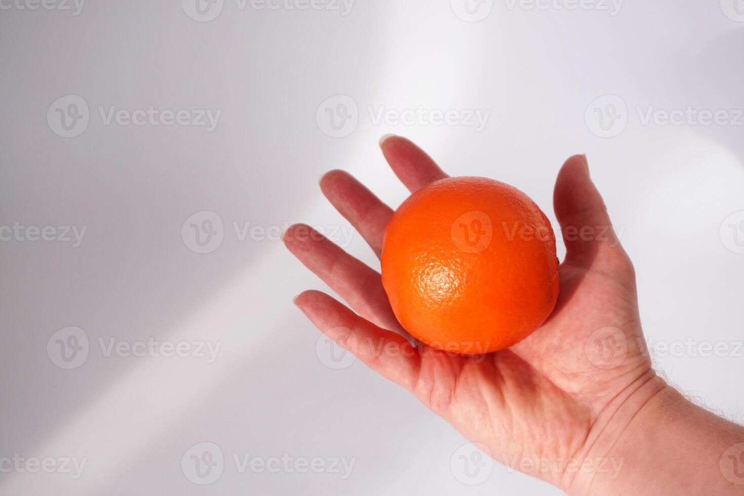 Hand offering an orange photo