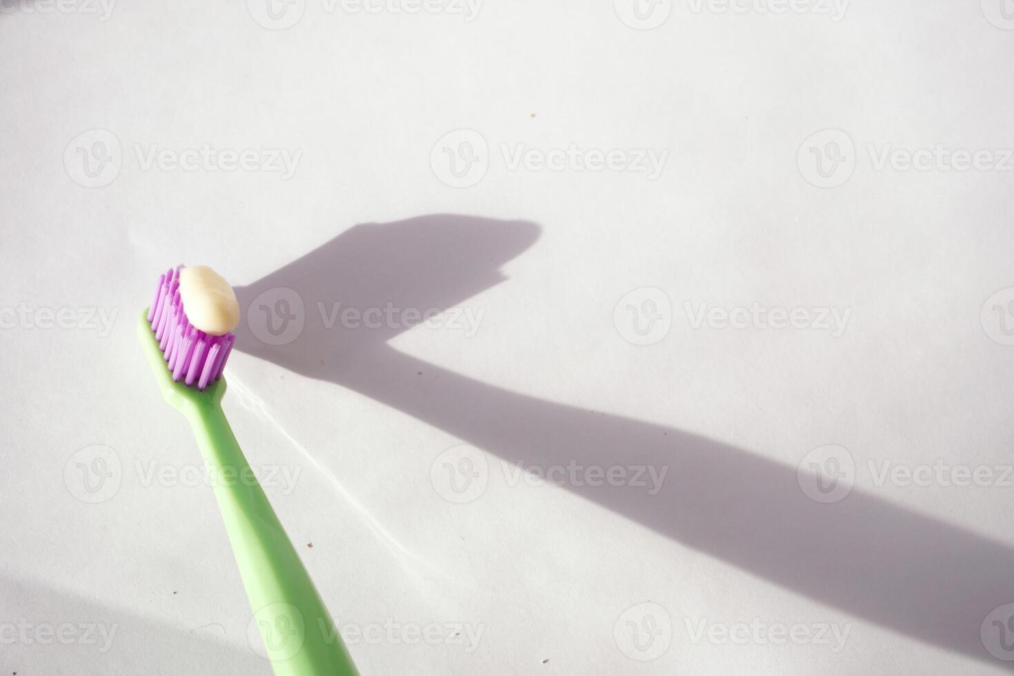 Toothbrush with toothpaste casting a sharp shadow photo