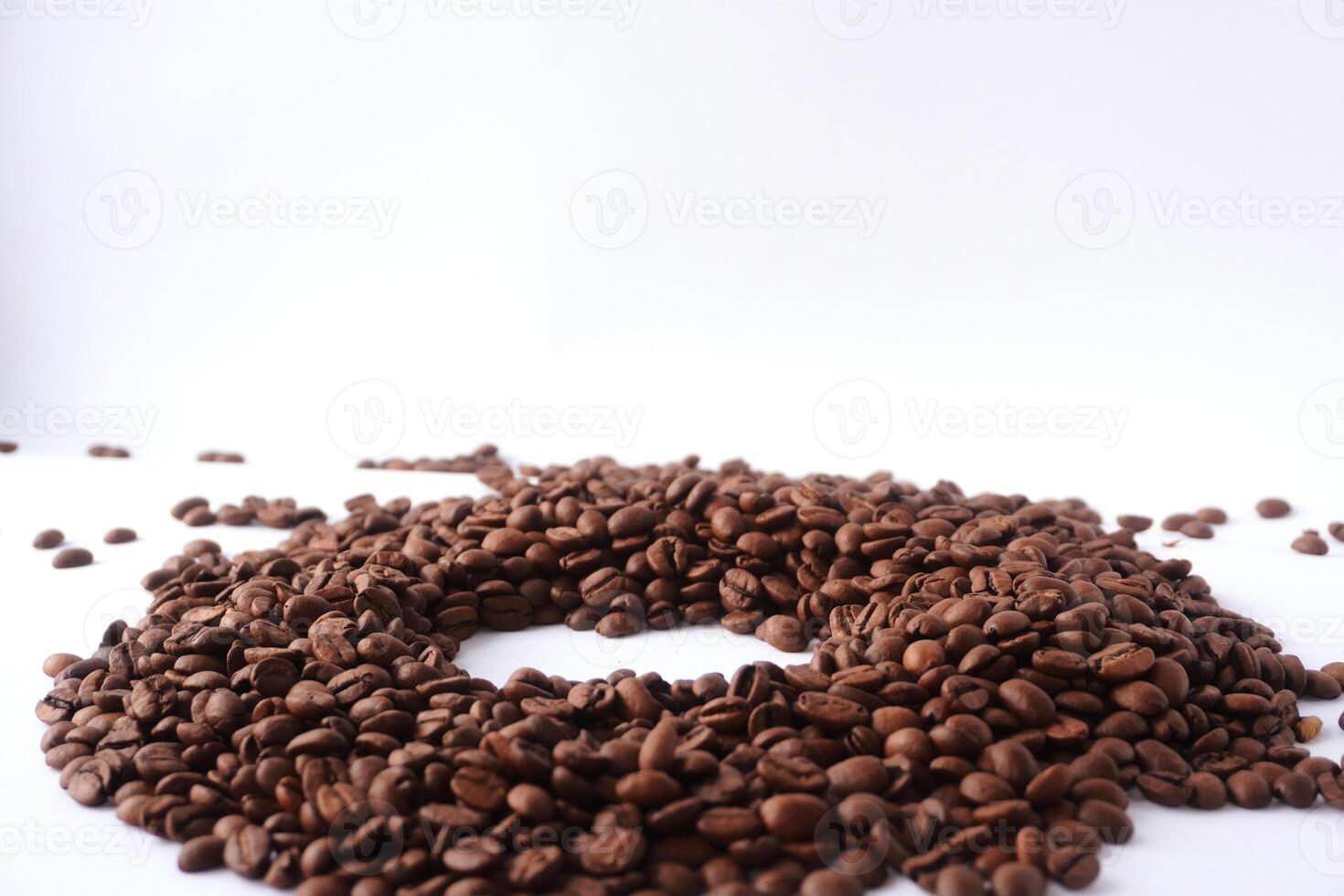 Roasted coffee beans in a circular arrangement on white background photo