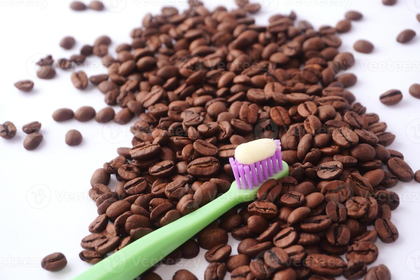Toothbrush with toothpaste on scattered coffee beans photo