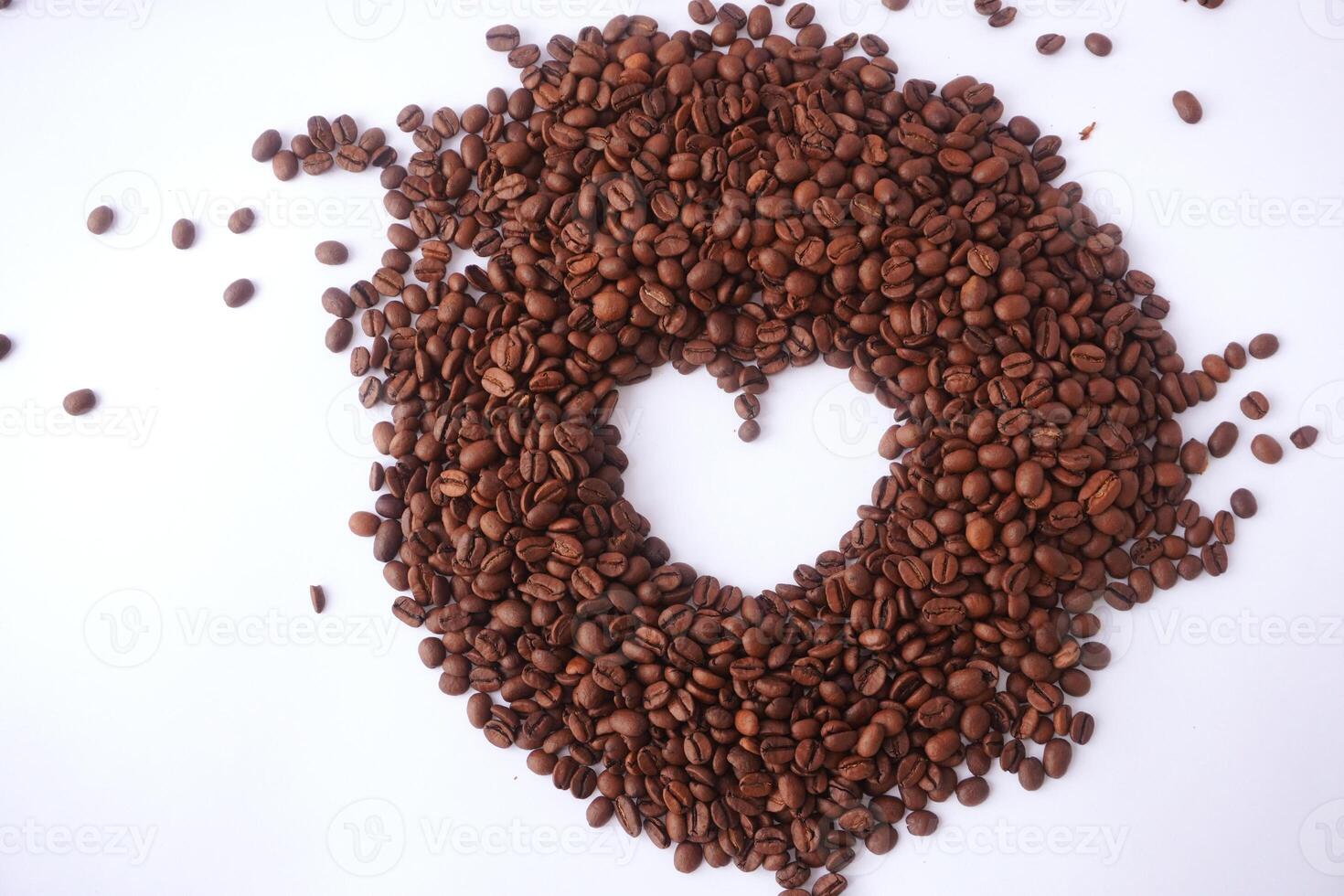 Heart-shaped coffee beans arrangement on white background photo