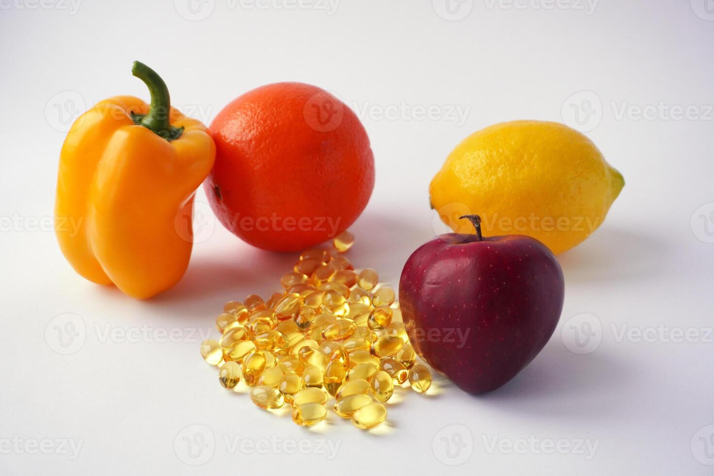 Bright fruits and vegetables with golden vitamin capsules on white photo