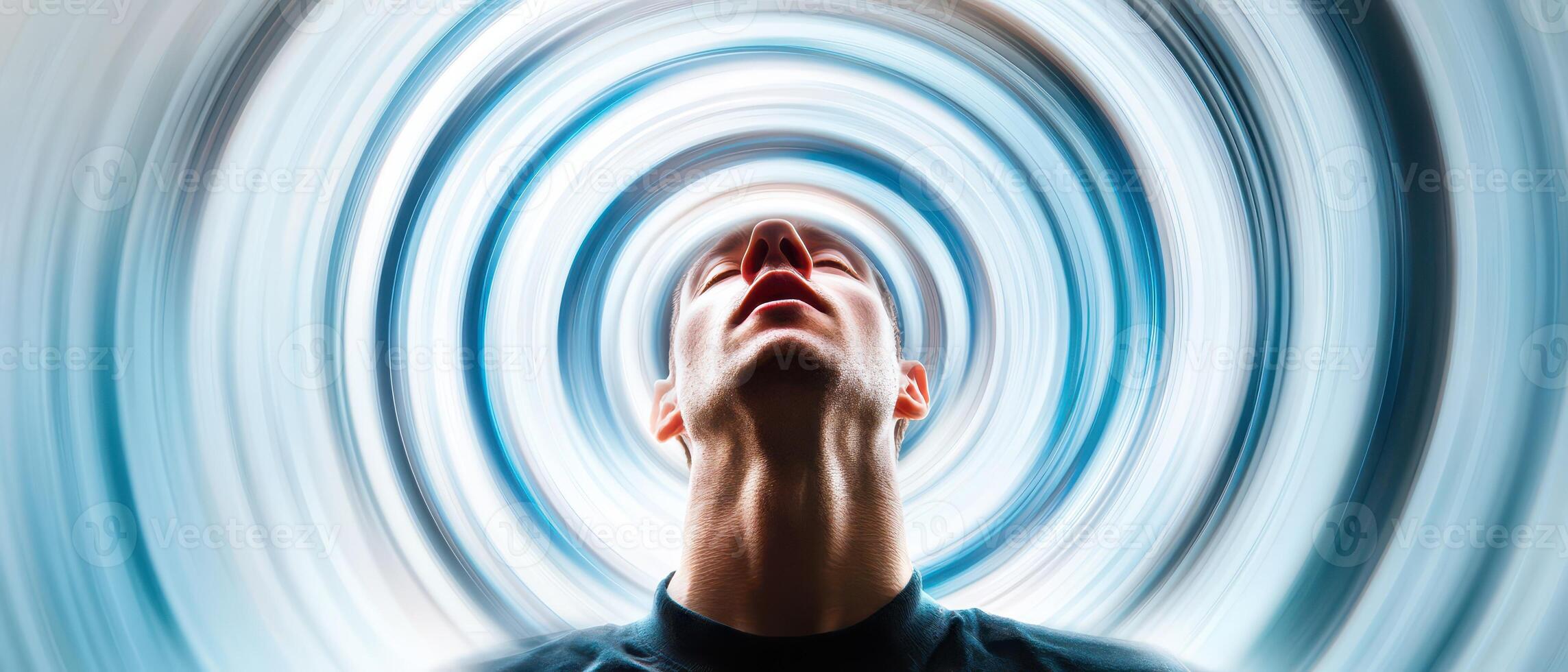 A man is looking up into the air with a blue swirl around him photo