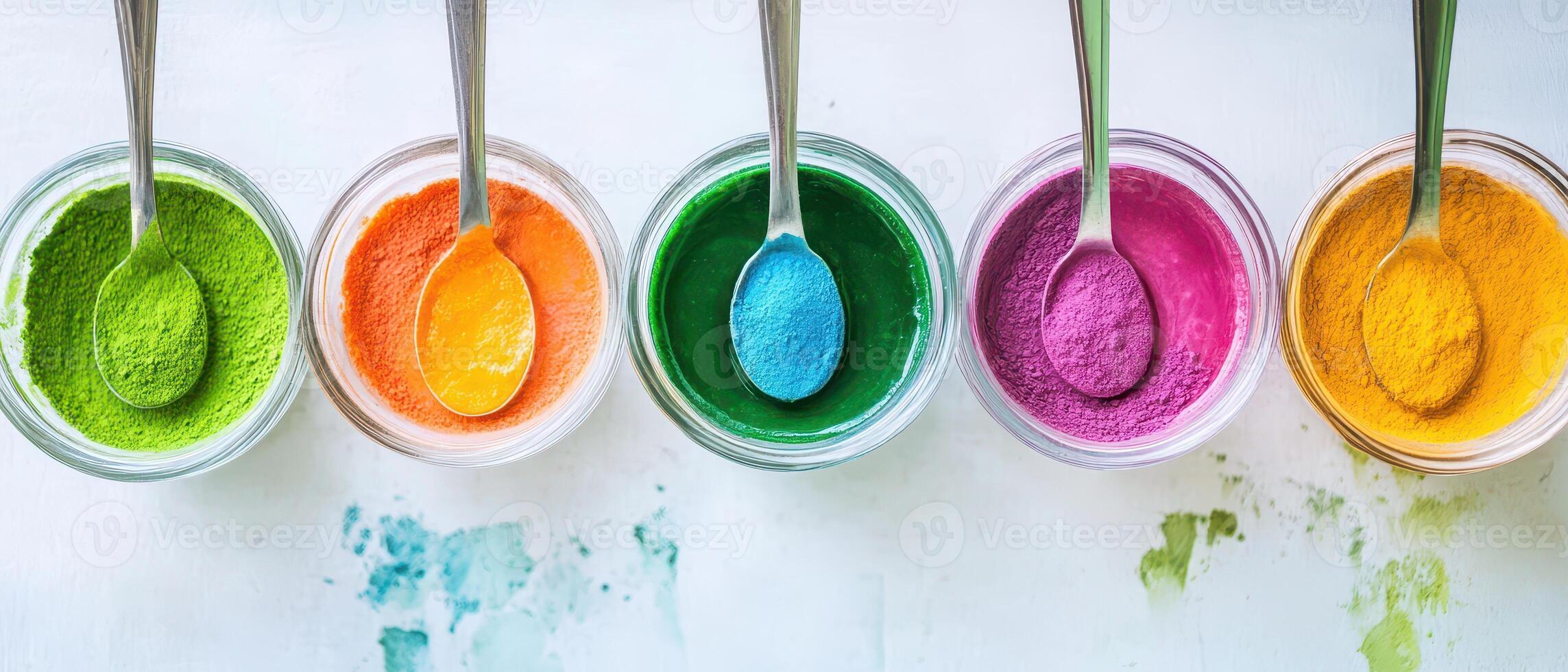 Colorful paint in bowls with spoons photo