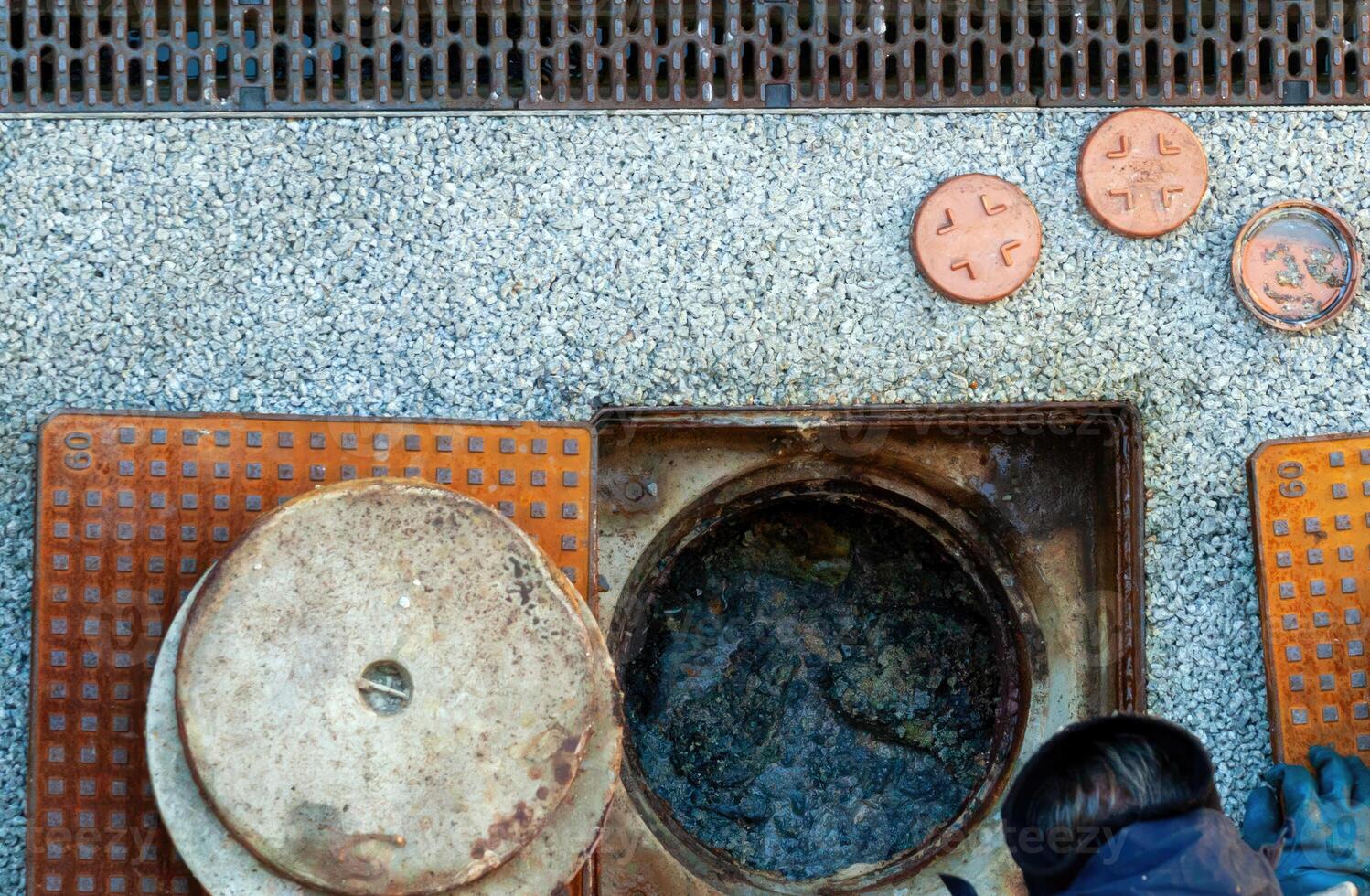 Plumber opening manhole for drain cleaning and unclogging sewer pipes photo