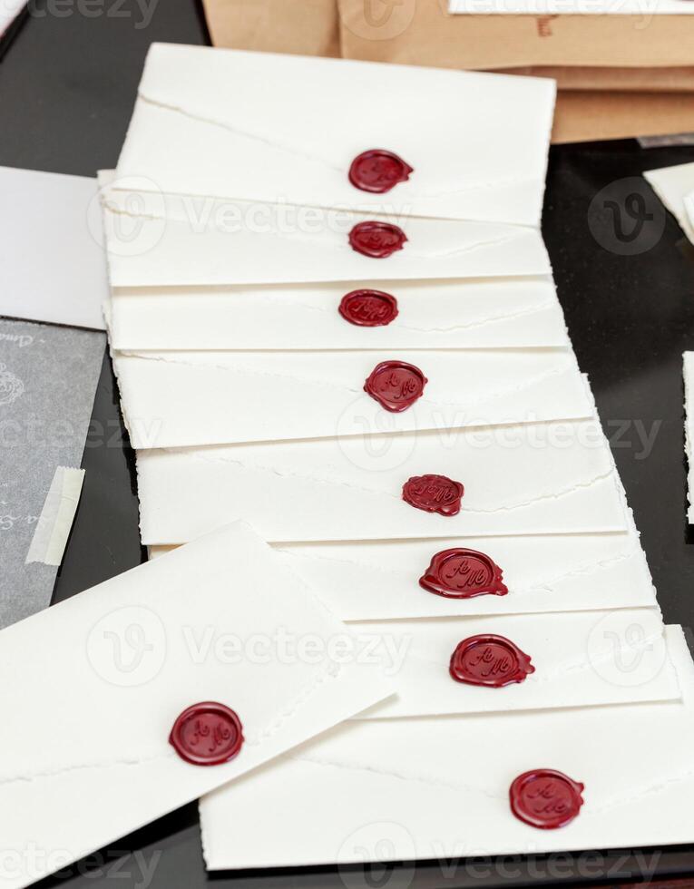 Elegant wedding invitations with red wax seals waiting to be sent photo