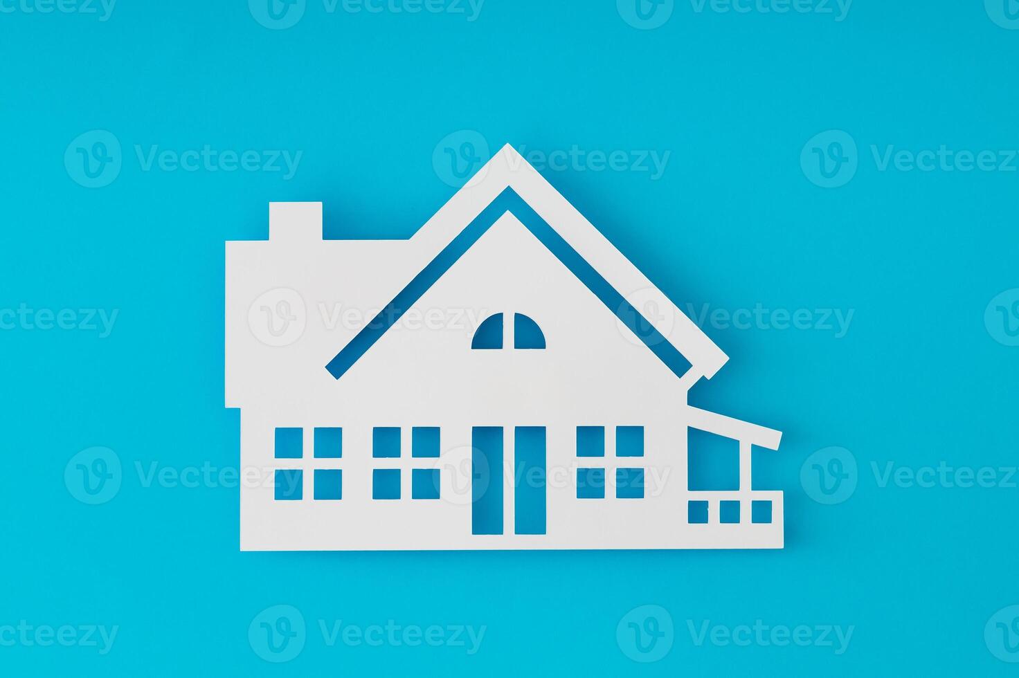 House shaped paper cutout on light blue background. Minimal concept. Flat lay style. Top view banner. photo