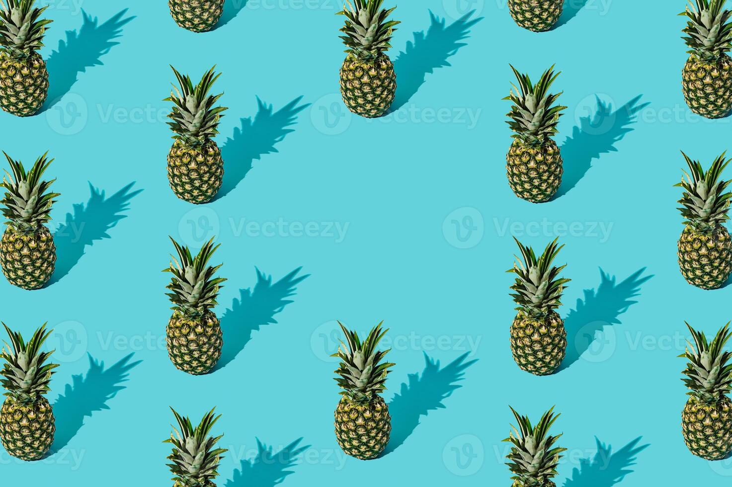 Trendy sunlight summer fruit pattern made of pineapples on light blue background with copy space. Nature summer concept. Ananas backdrop idea image. Pineapple aesthetic. photo