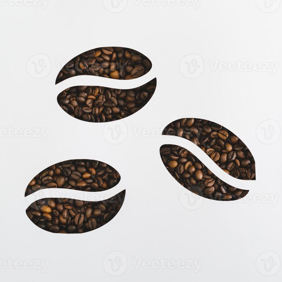 Coffee beans visible through a coffee beans shaped gaps on white background. Minimal concept. Coffee aesthetic. Flat lay, top view banner. photo