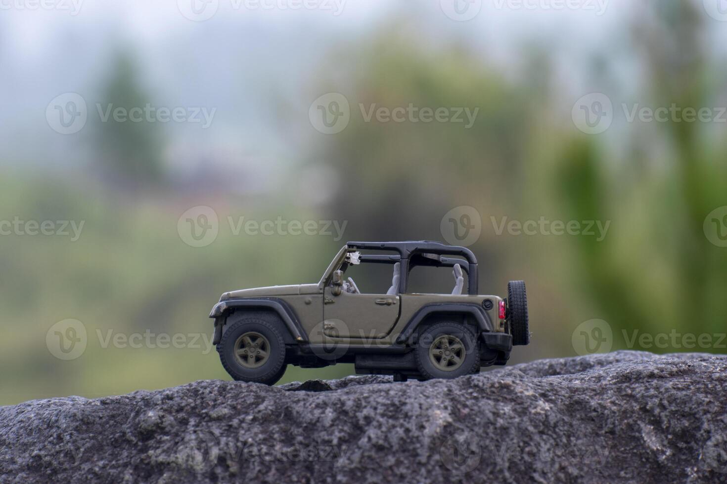 An off road toy car on the stone with bokeh background. An adventure conceptual of a diecast car miniature. photo