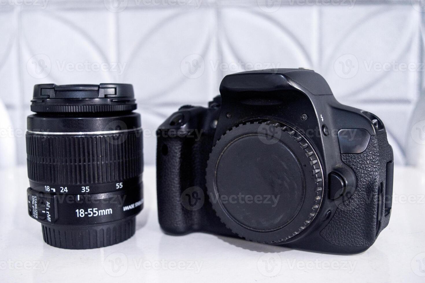A DSLR camera and a standard zoom lens with focal length range 18-55 mm. photo