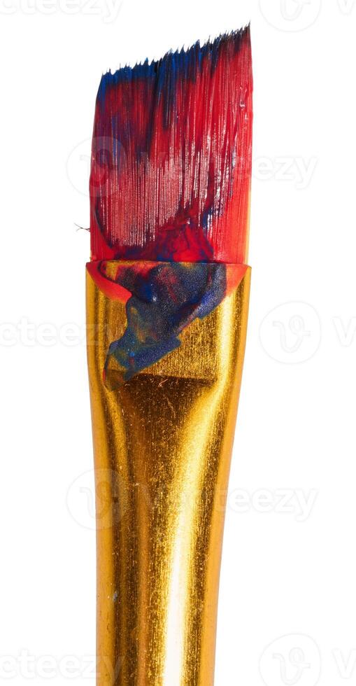 Brush with red oil paint on isolated background, bristles photo