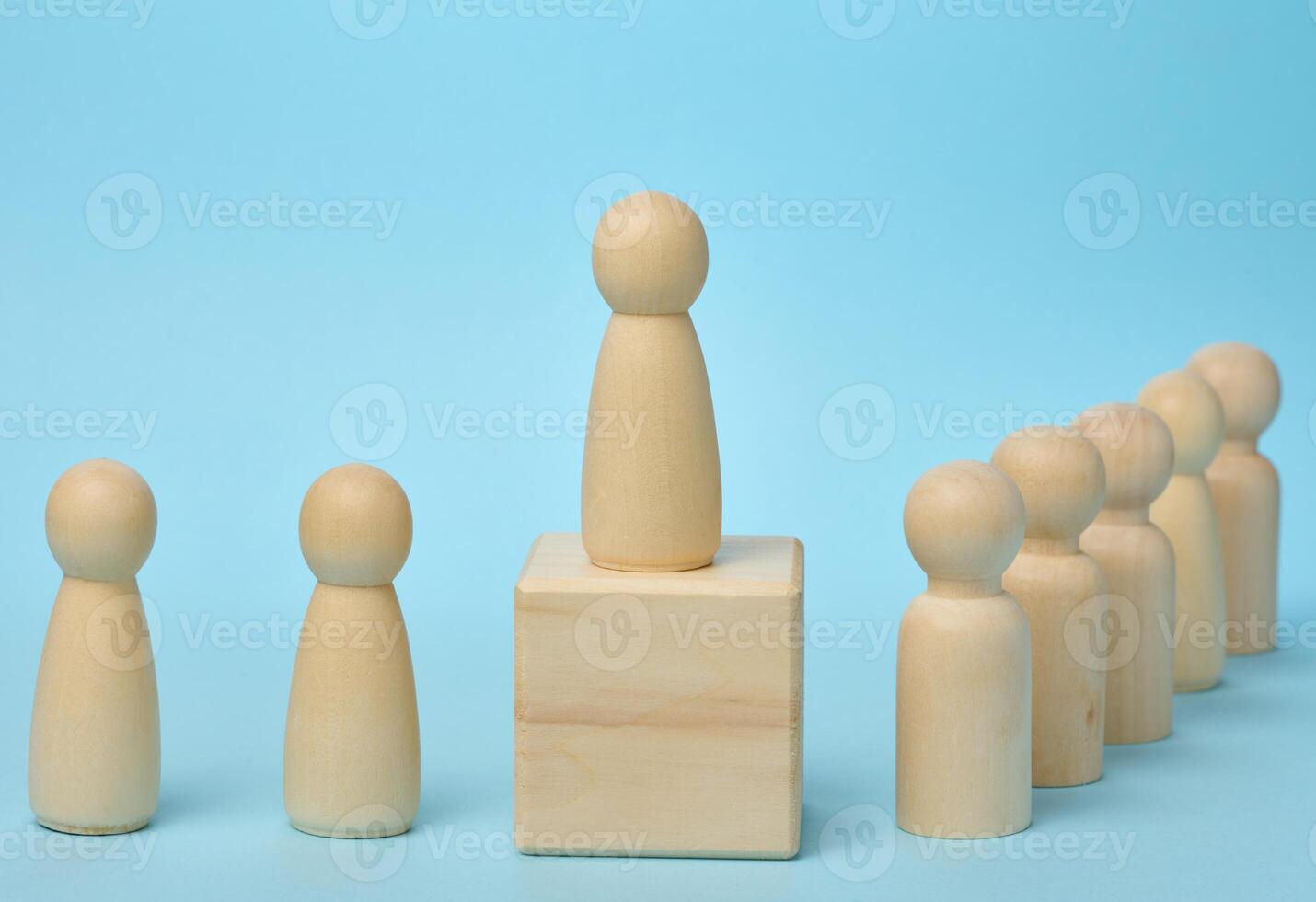 Wooden figurines of men on a blue background. Public speaking concept, leadership and discussion. The team unites around an idea, cooperation photo