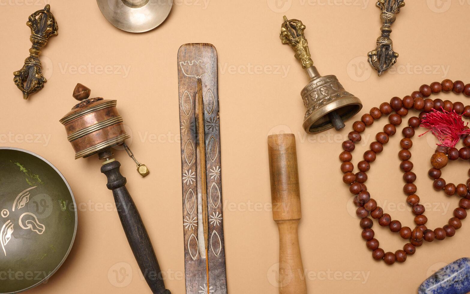 Tibetan singing copper bowl with a wooden clapper on a brown background, objects for meditation and alternative medicine, top view photo