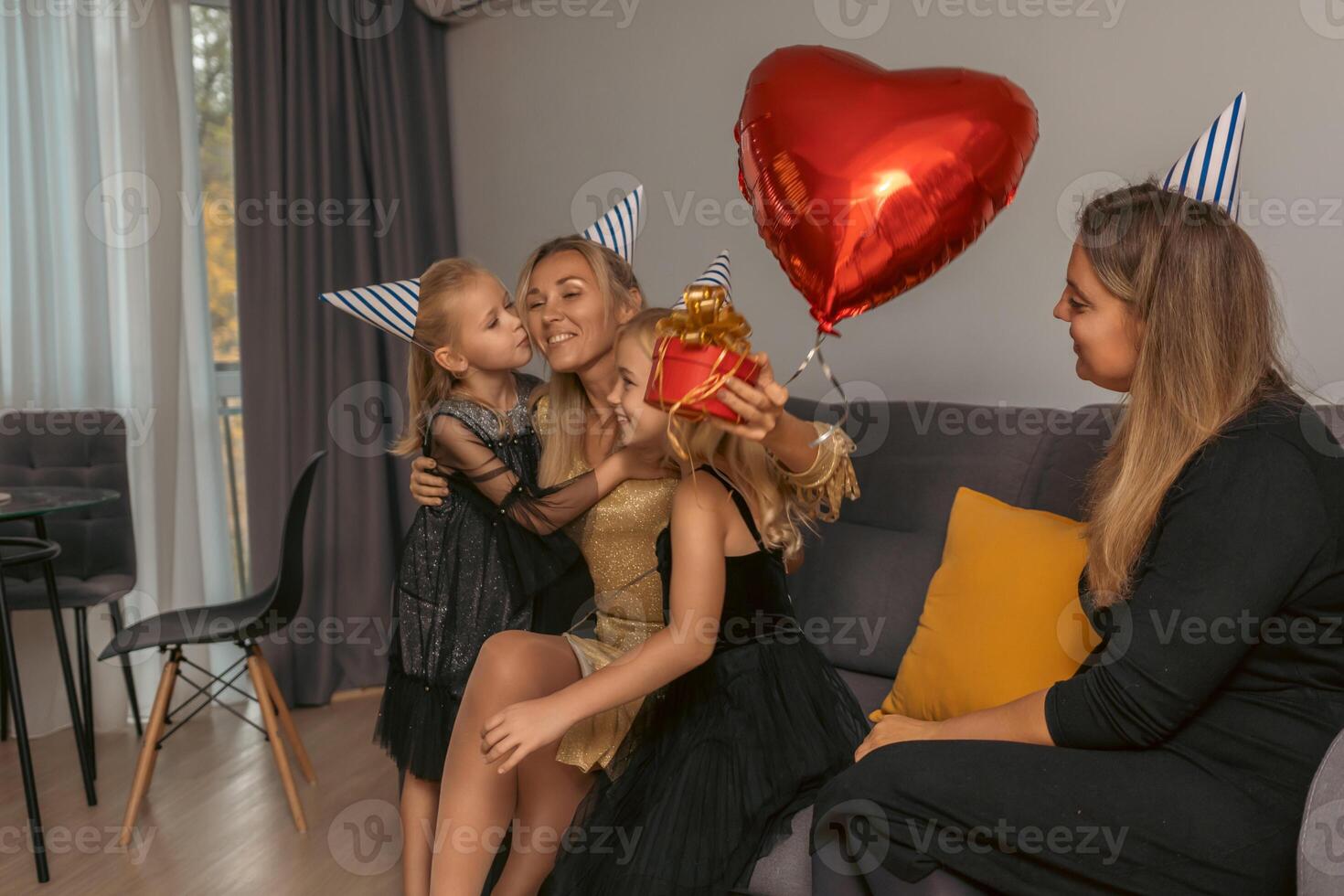 Birthday Party Family Celebration Home. Girls kissing mom, presents, balloon indoor festive scene. photo