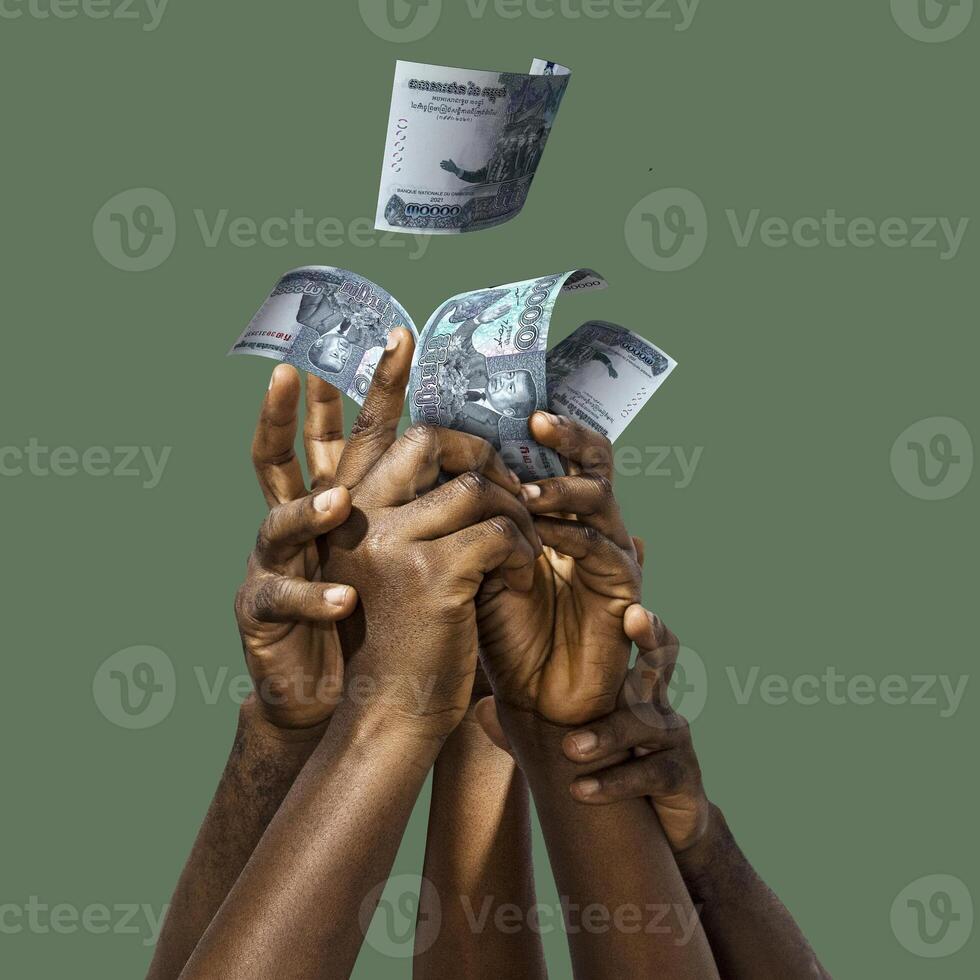 Many black African hands reaching out for Cambodian Riel notes money over green background. Stretching arms for cash photo