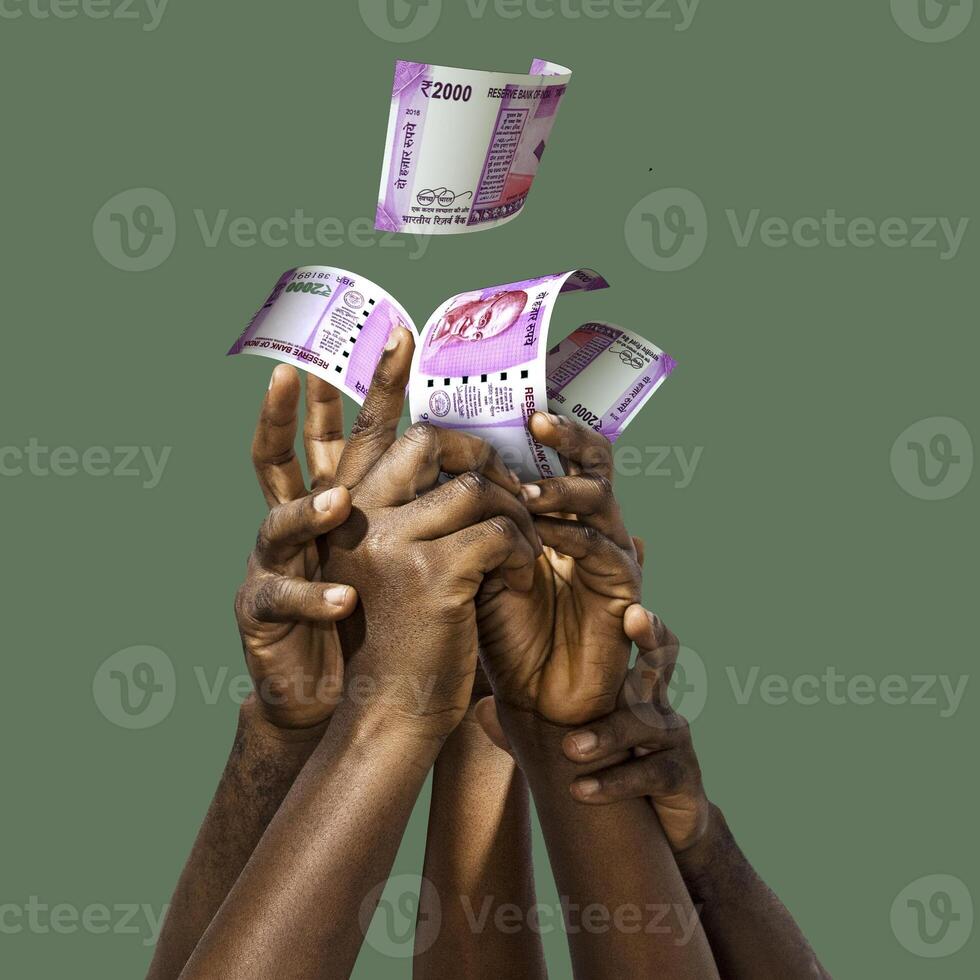 Many black African hands reaching out for Indian Rupee notes money over green background. Stretching arms for cash photo