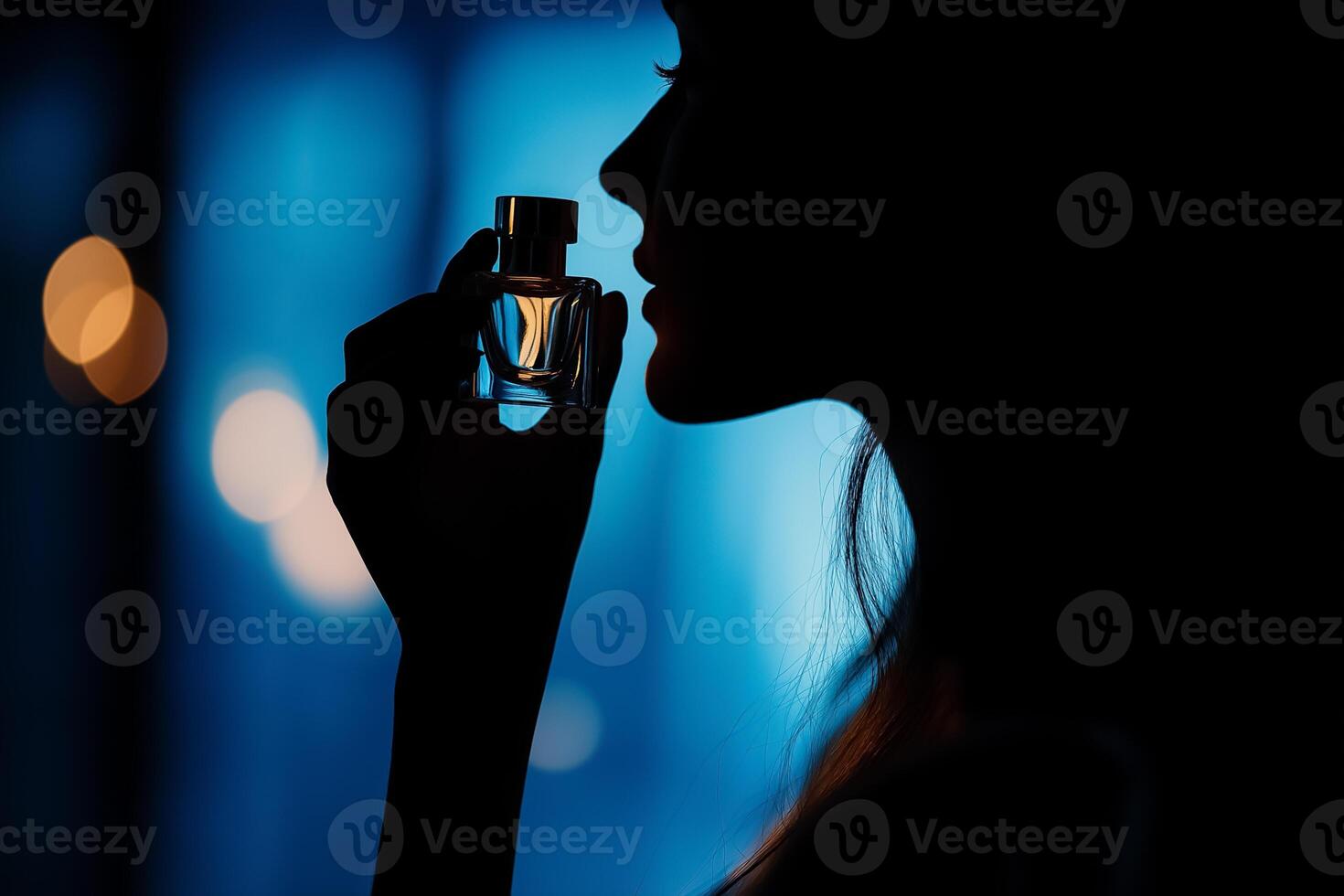A woman is holding a perfume bottle in her hand photo