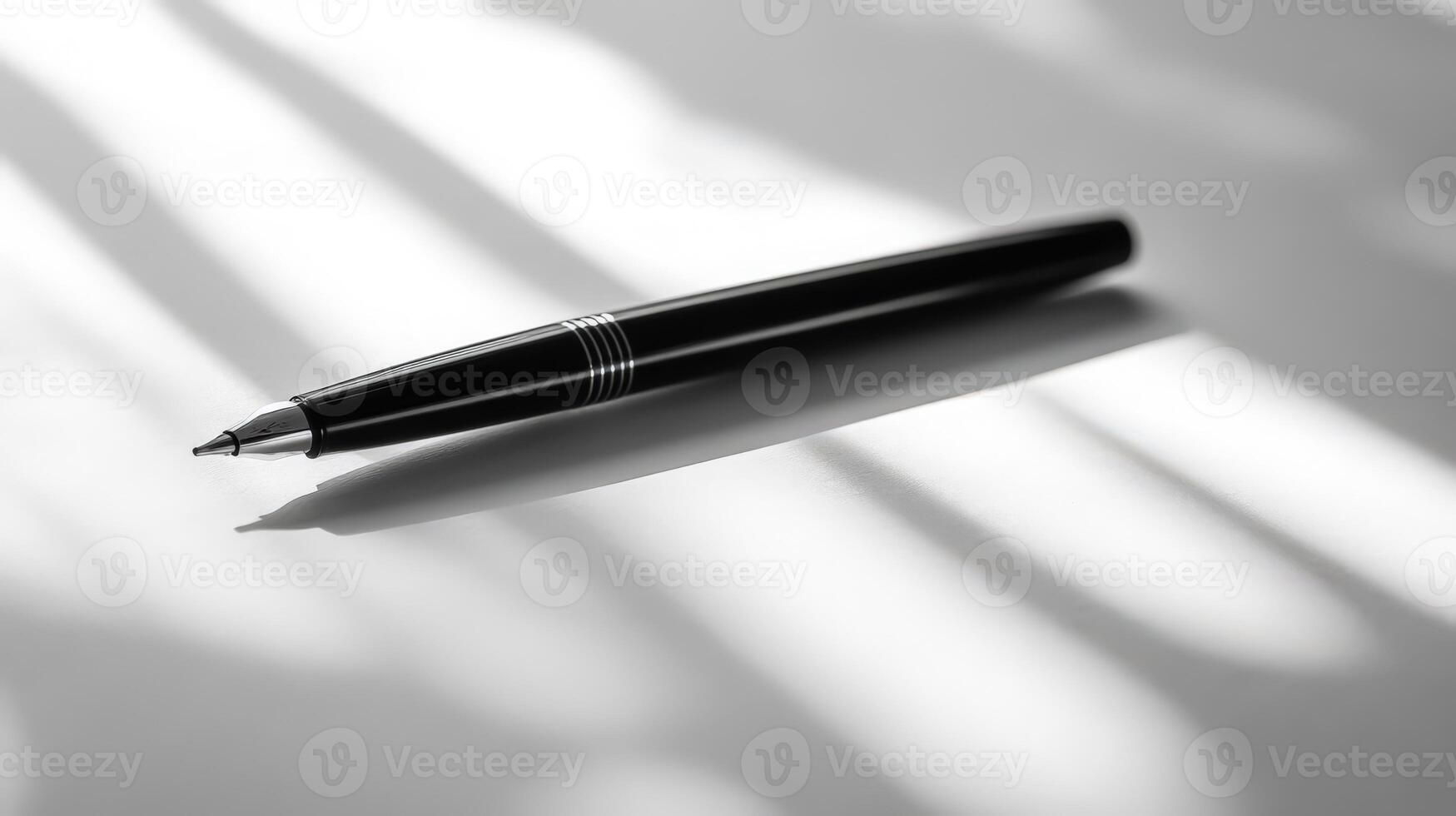 A black and white photo of a pen on a table