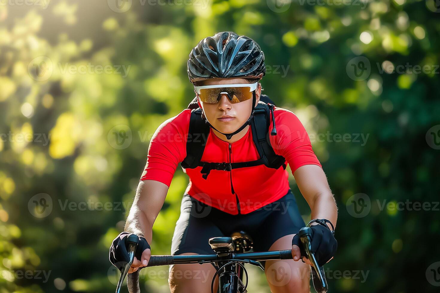 A female cyclist in a red shirt and sunglasses riding a bike photo