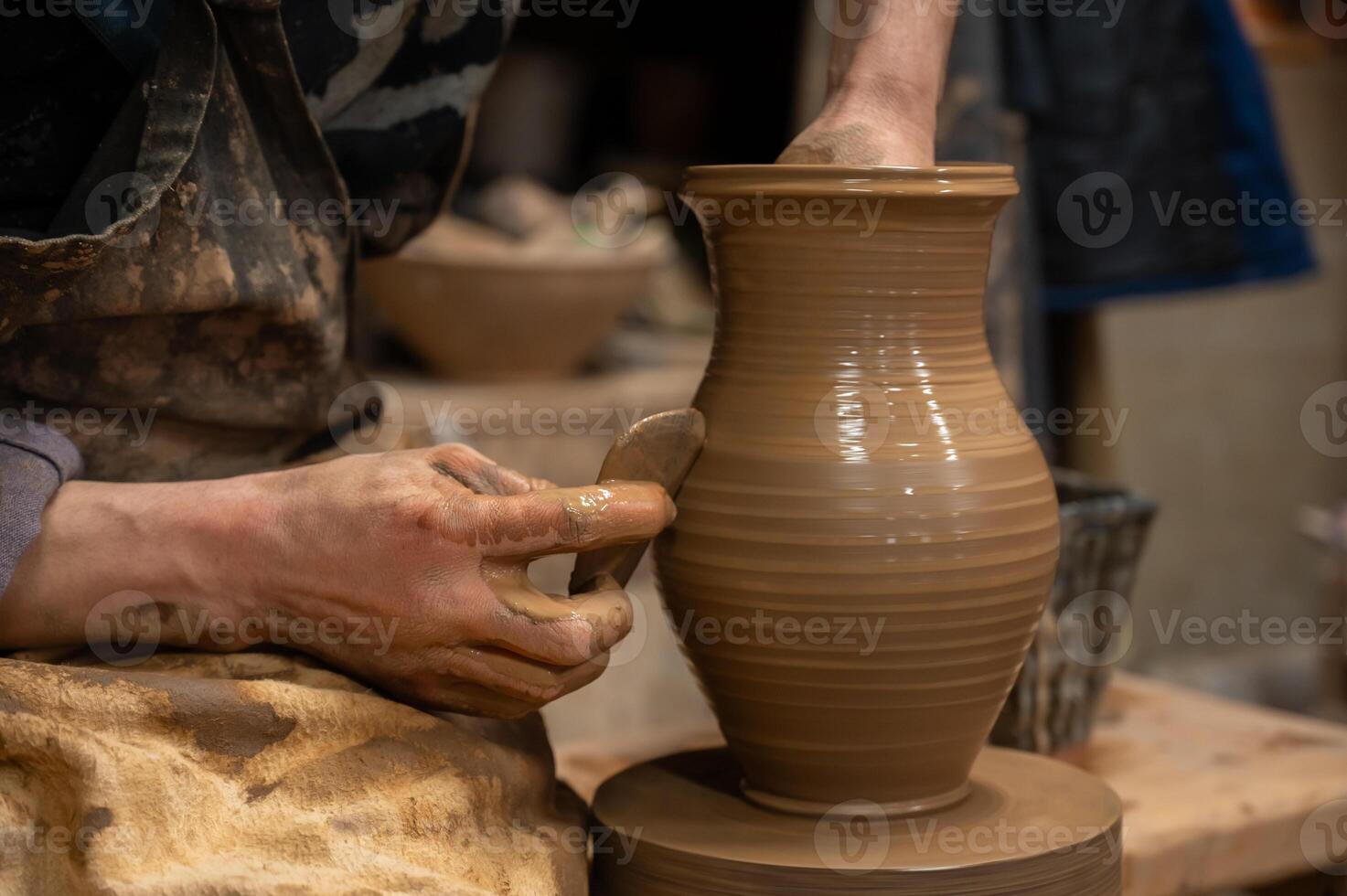 A potter is making a vase on a potter wheel photo