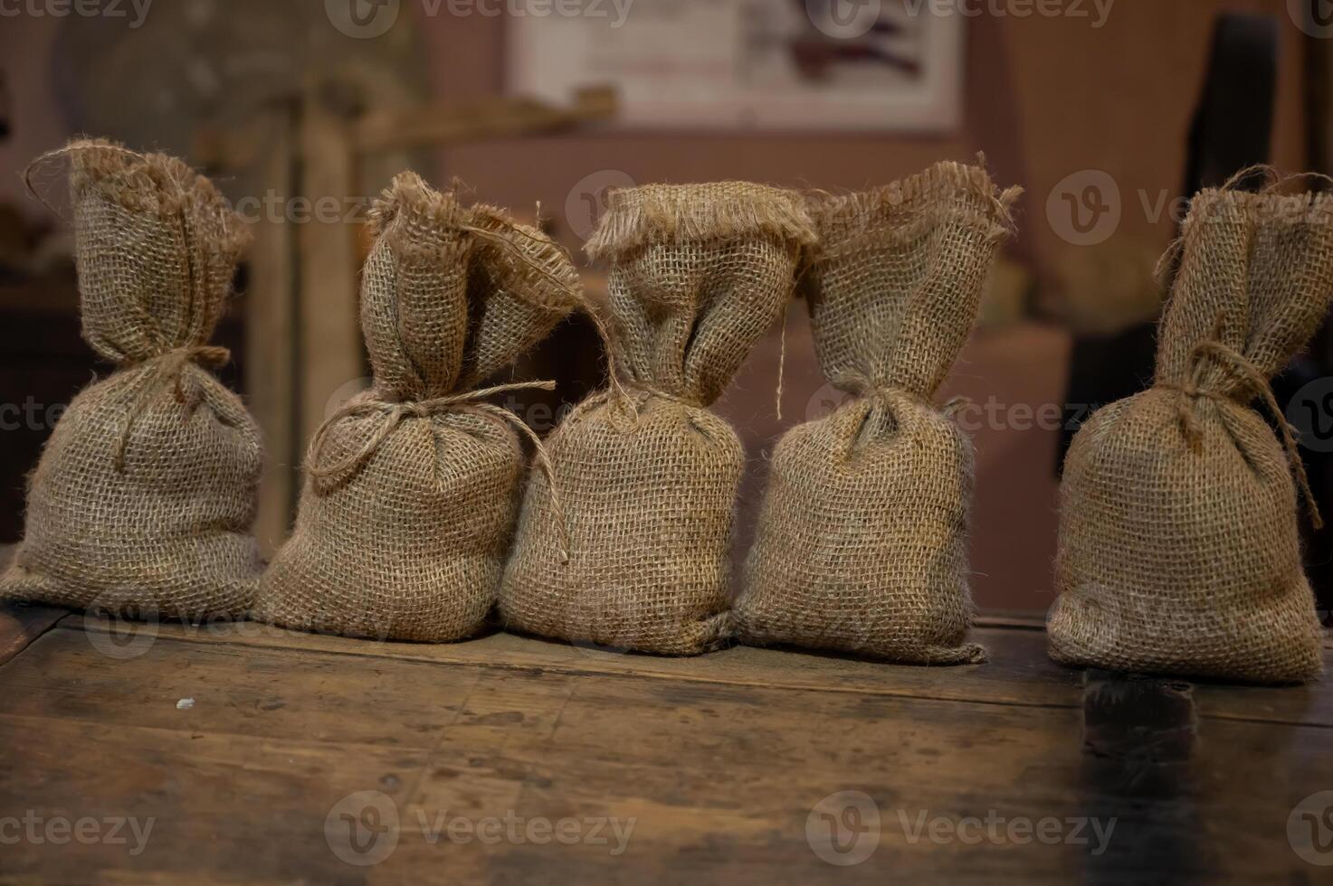 Several bags of burlap tied with string on a wooden table photo