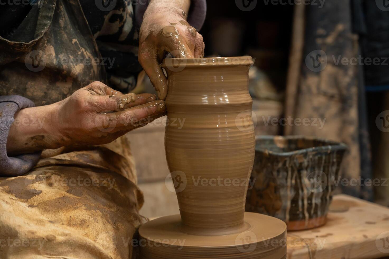a potter is working on a vase on a potter wheel photo