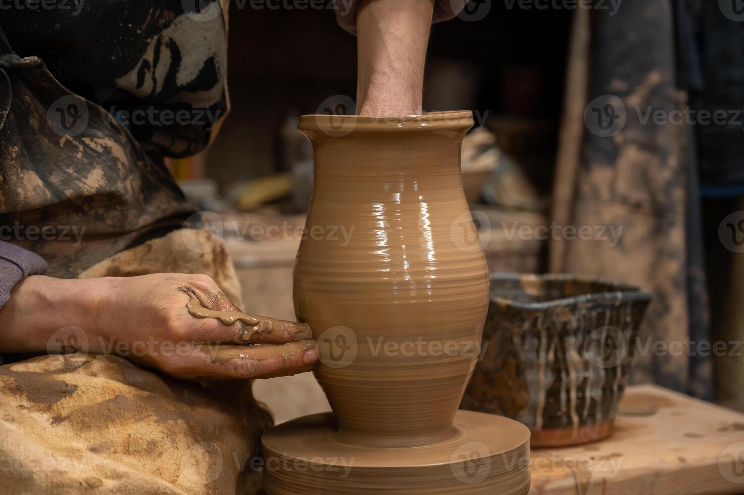a potter making a vase on a potter wheel photo